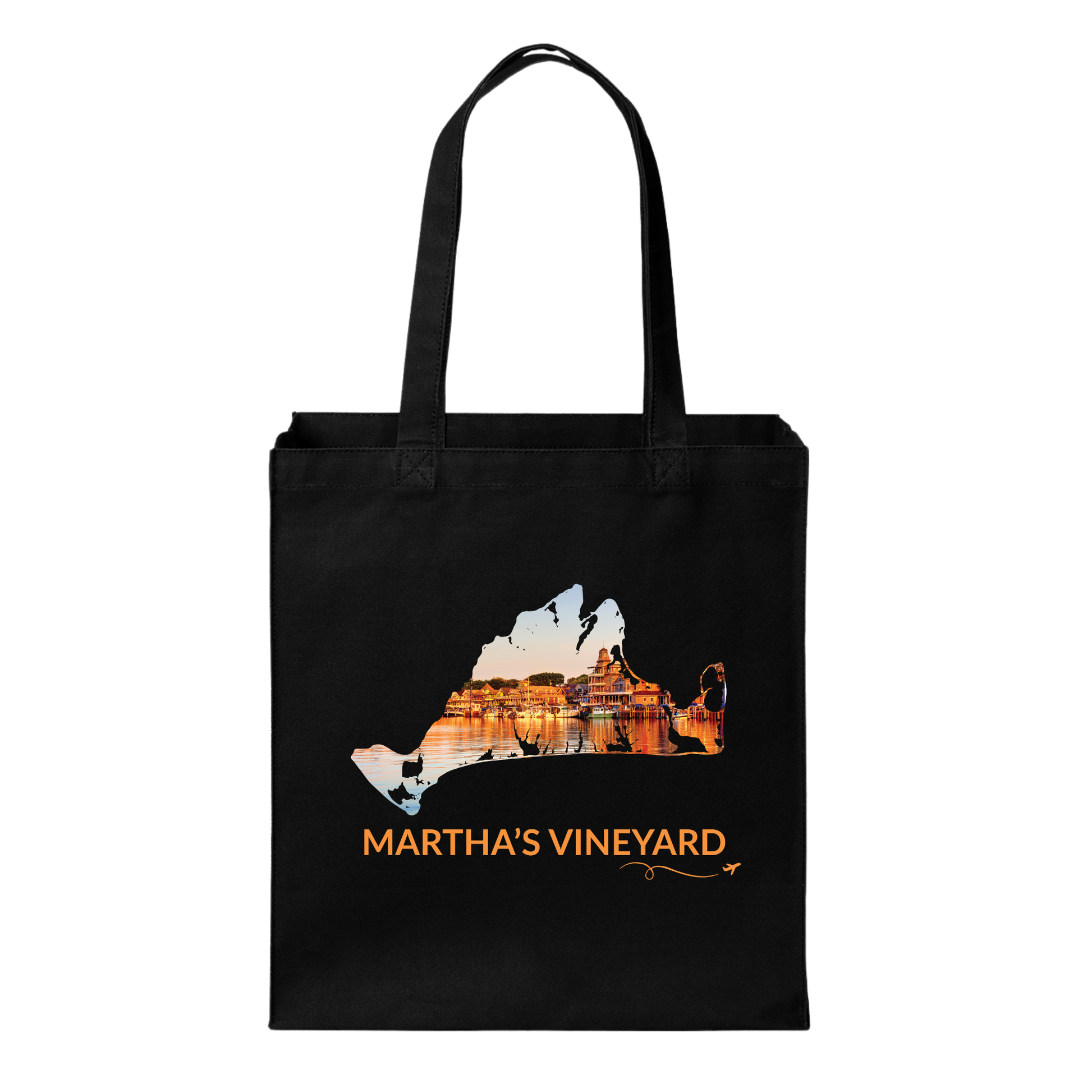 Black cotton canvas tote bag featuring a hand-drawn Martha's Vineyard outline filled with Oak Bluffs Harbor at sunset, with boats, waterfront buildings, and golden reflections on the water. The words "Martha's Vineyard" appear below the artwork with a small airplane icon and looping flight path.