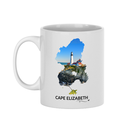White 11 oz Cape Elizabeth mug featuring Portland Head Light, rocky coastline and blue ocean inside the Cape Elizabeth outline, black Cape Elizabeth lettering, and a small airplane with swirl