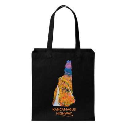 Black canvas tote bag featuring a hand-drawn New Hampshire outline filled with an aerial photograph of the Kancamagus Highway winding through colorful fall foliage. The words “Kancamagus Highway” appear below with a small airplane icon and looping flight path.