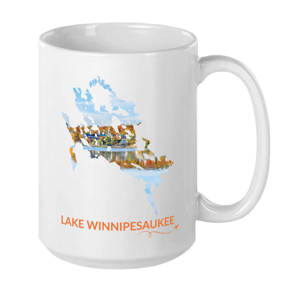 White 15 oz ceramic mug featuring a hand-drawn outline of Lake Winnipesaukee filled with a photograph of Meredith, New Hampshire, with autumn foliage and lakeside buildings reflected in the water. The words “Lake Winnipesaukee” appear below the artwork with a small airplane icon and looping flight path.