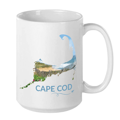 White 15 oz Cape Cod mug featuring a beach scene with sand fence, dunes, ocean and beach roses inside the Cape Cod outline, blue Cape Cod lettering, and a small airplane with swirl