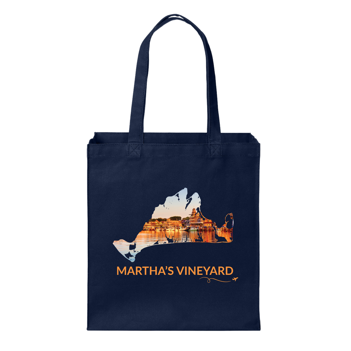 Navy cotton canvas tote bag featuring a hand-drawn Martha's Vineyard outline showcasing Oak Bluffs Harbor at sunset with glowing waterfront buildings reflected in the harbor. The words "Martha's Vineyard" appear below the artwork with a small airplane icon and looping flight path.
