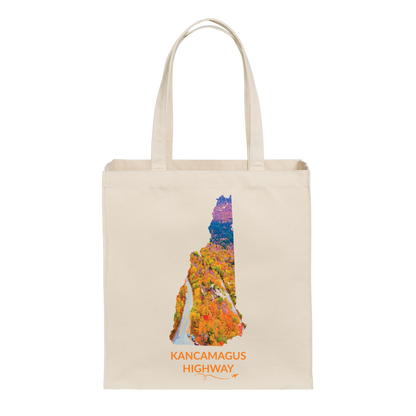 Natural canvas tote bag featuring a hand-drawn New Hampshire outline filled with an aerial photograph of the Kancamagus Highway winding through colorful fall foliage. The words “Kancamagus Highway” appear below with a small airplane icon and looping flight path.