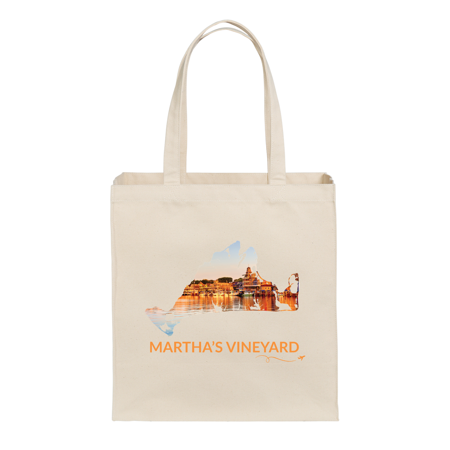 Natural cotton canvas tote bag featuring a hand-drawn Martha's Vineyard outline with Oak Bluffs Harbor at sunset, including boats, waterfront buildings, and shimmering reflections on the water. The words "Martha's Vineyard" appear below the artwork with a small airplane icon and looping flight path.