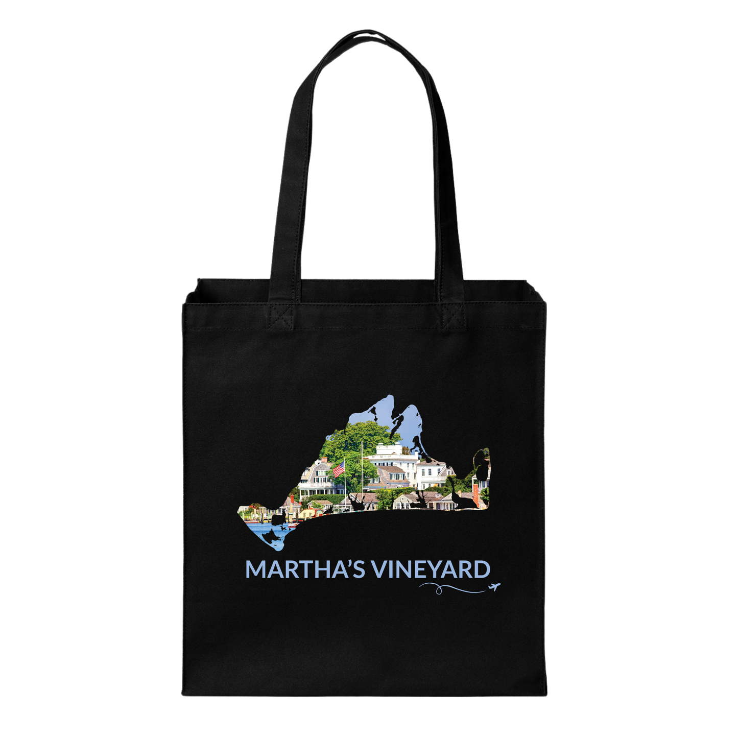 Black cotton canvas tote bag featuring a hand-drawn Martha's Vineyard outline filled with Edgartown Harbor, historic homes, and coastal scenery. The words "Martha's Vineyard" appear below the artwork with a small airplane icon and looping flight path.