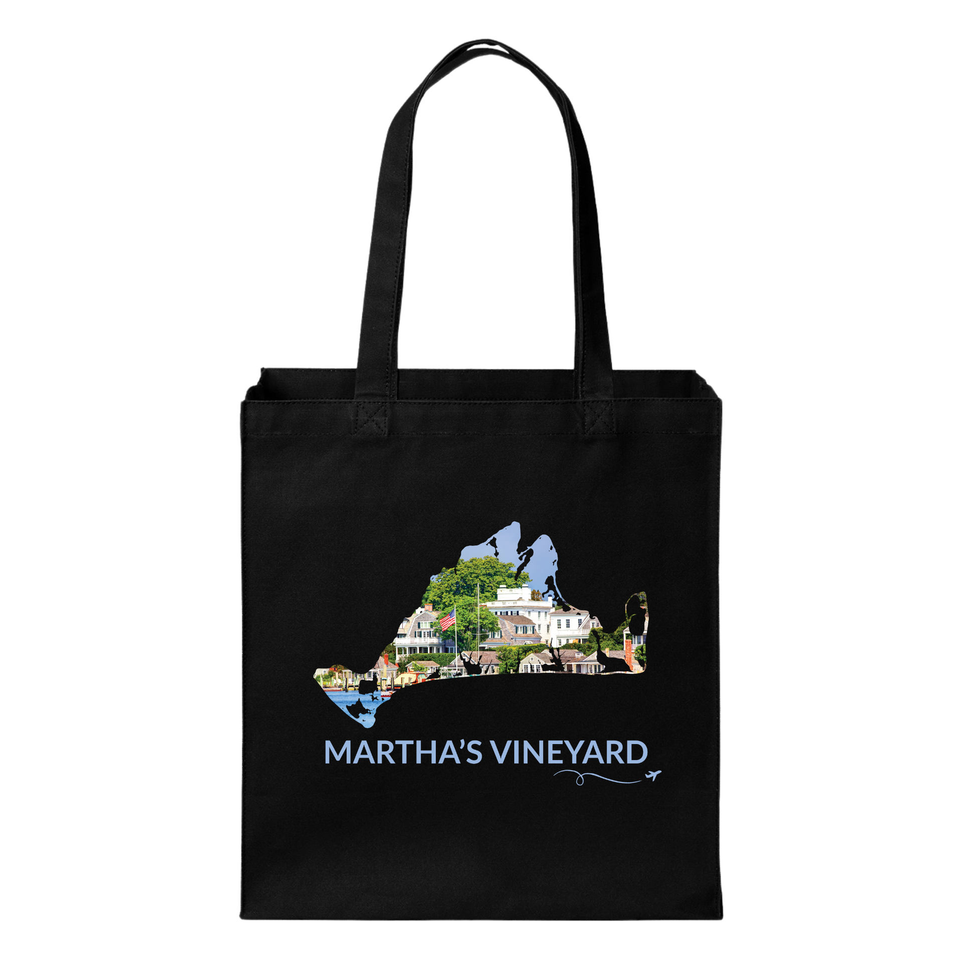 Black cotton canvas tote bag featuring a hand-drawn Martha's Vineyard outline filled with Edgartown Harbor, historic homes, and coastal scenery. The words "Martha's Vineyard" appear below the artwork with a small airplane icon and looping flight path.