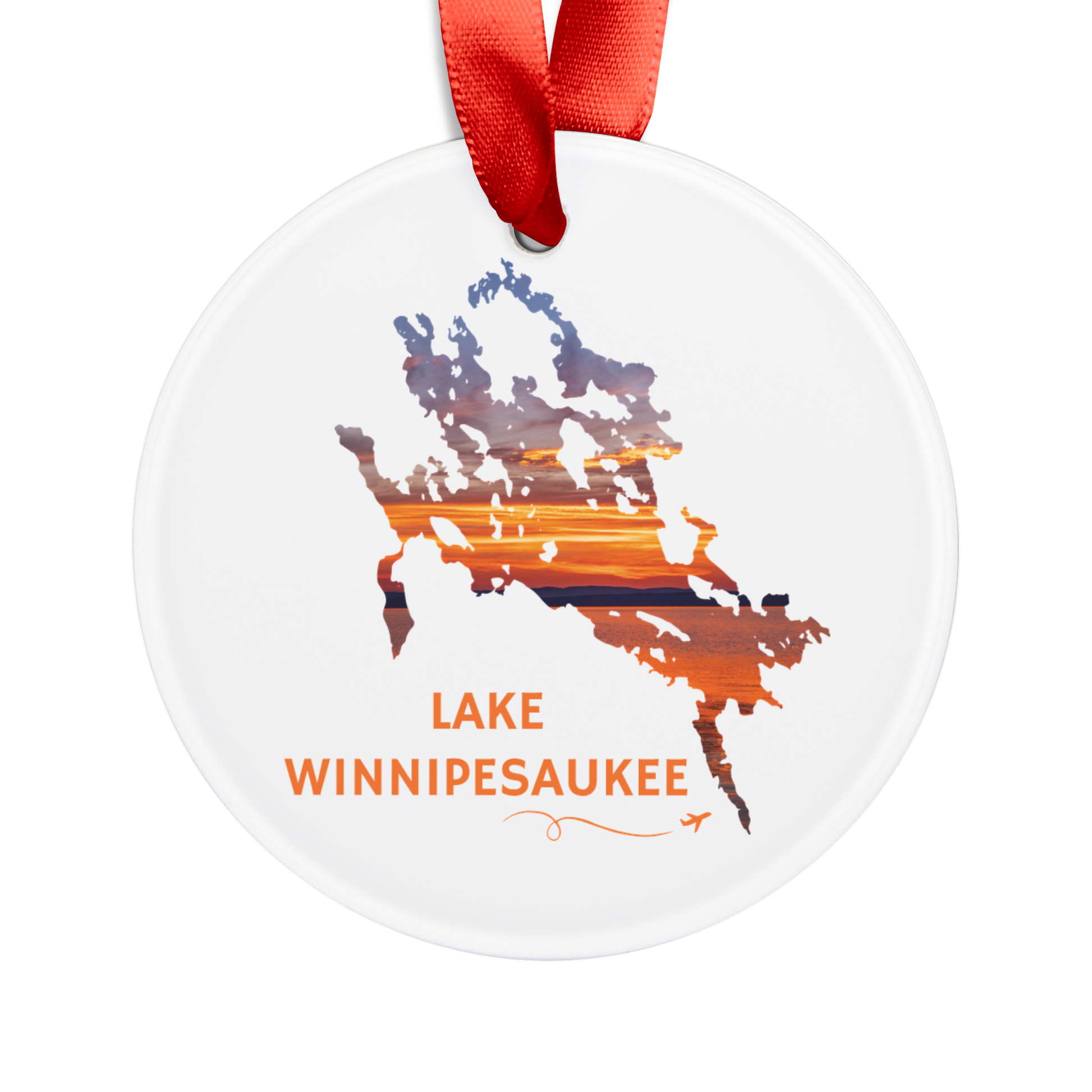Round acrylic ornament featuring a hand-drawn outline of Lake Winnipesaukee filled with a vibrant sunset over the lake. The words "Lake Winnipesaukee" appear below the artwork with a small airplane icon and looping flight path.