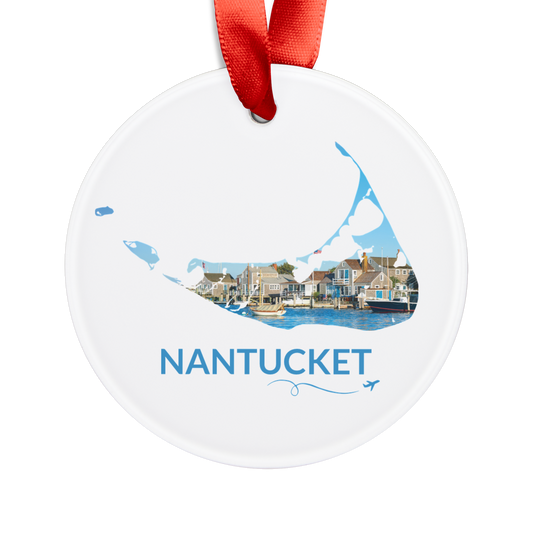 White Nantucket ornament with red ribbon, featuring Nantucket Harbor and waterfront buildings inside the island outline, blue Nantucket lettering, and a small airplane with swirl