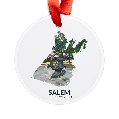 White Salem ornament with red ribbon, featuring the Bewitched Sculpture inside the Salem outline, SALEM lettering, and a small airplane with swirl.