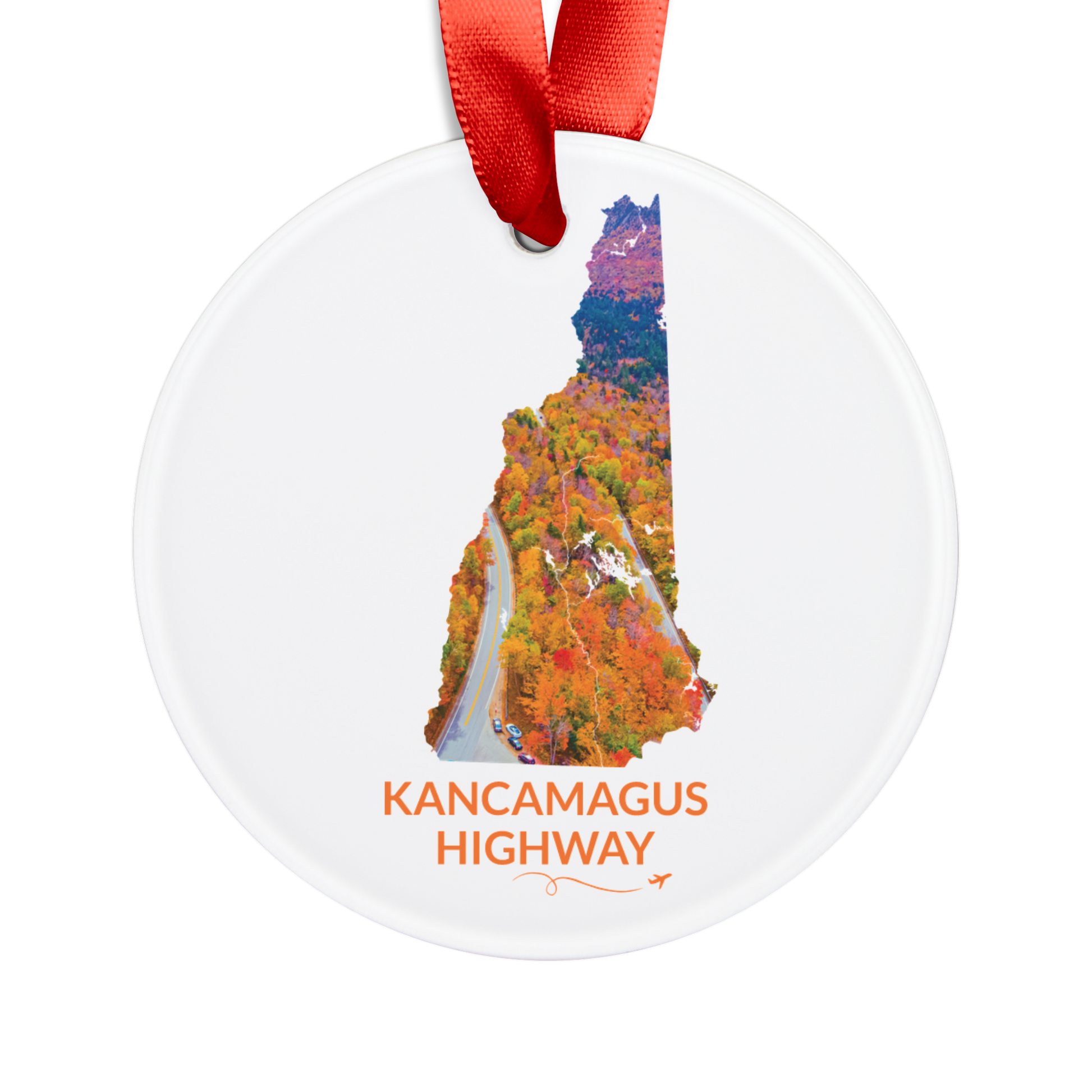 White round ornament featuring a hand-drawn New Hampshire outline filled with an aerial view of the Kancamagus Highway winding through vibrant fall foliage. “Kancamagus Highway” appears below with a looping flight path and airplane.