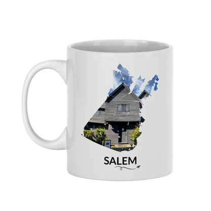 White 11 oz Salem, Massachusetts mug featuring a hand-drawn Salem outline filled with a real photograph of the Witch House, SALEM lettering underneath, and a plane with a swirl line.